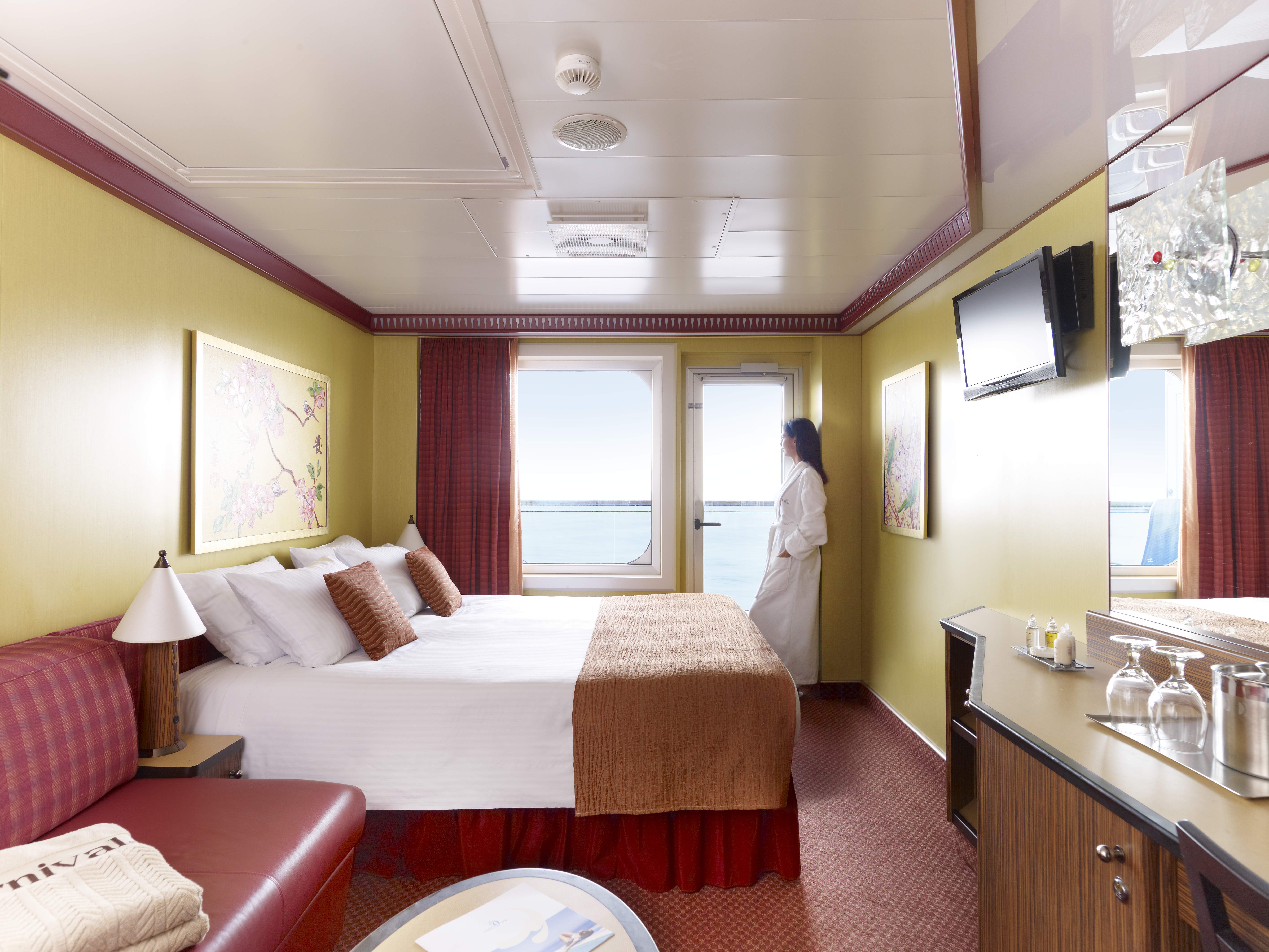 woman wearing a robe in a stateroom overlooking the ocean