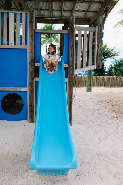 daughter at the top of a blue slide