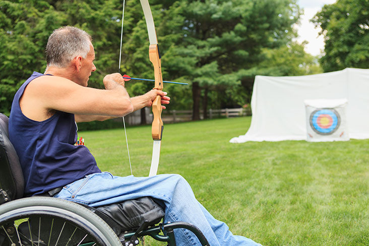 Man in wheelchair practising archery