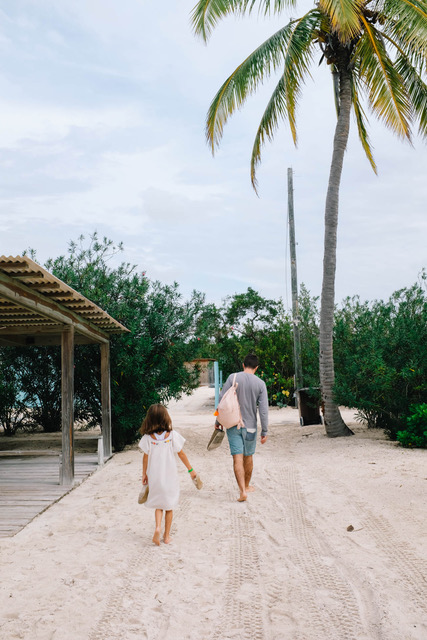 dad and daughter walking towards beach