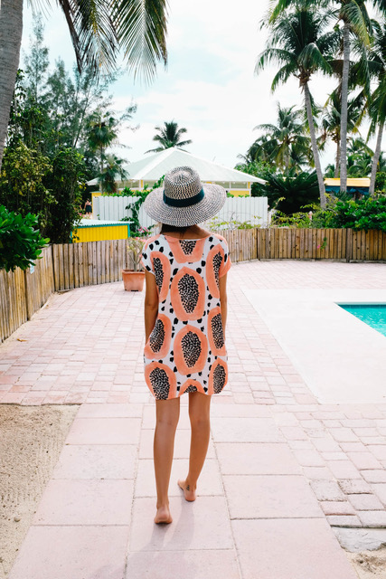 Drea walking by pool in patterned dress