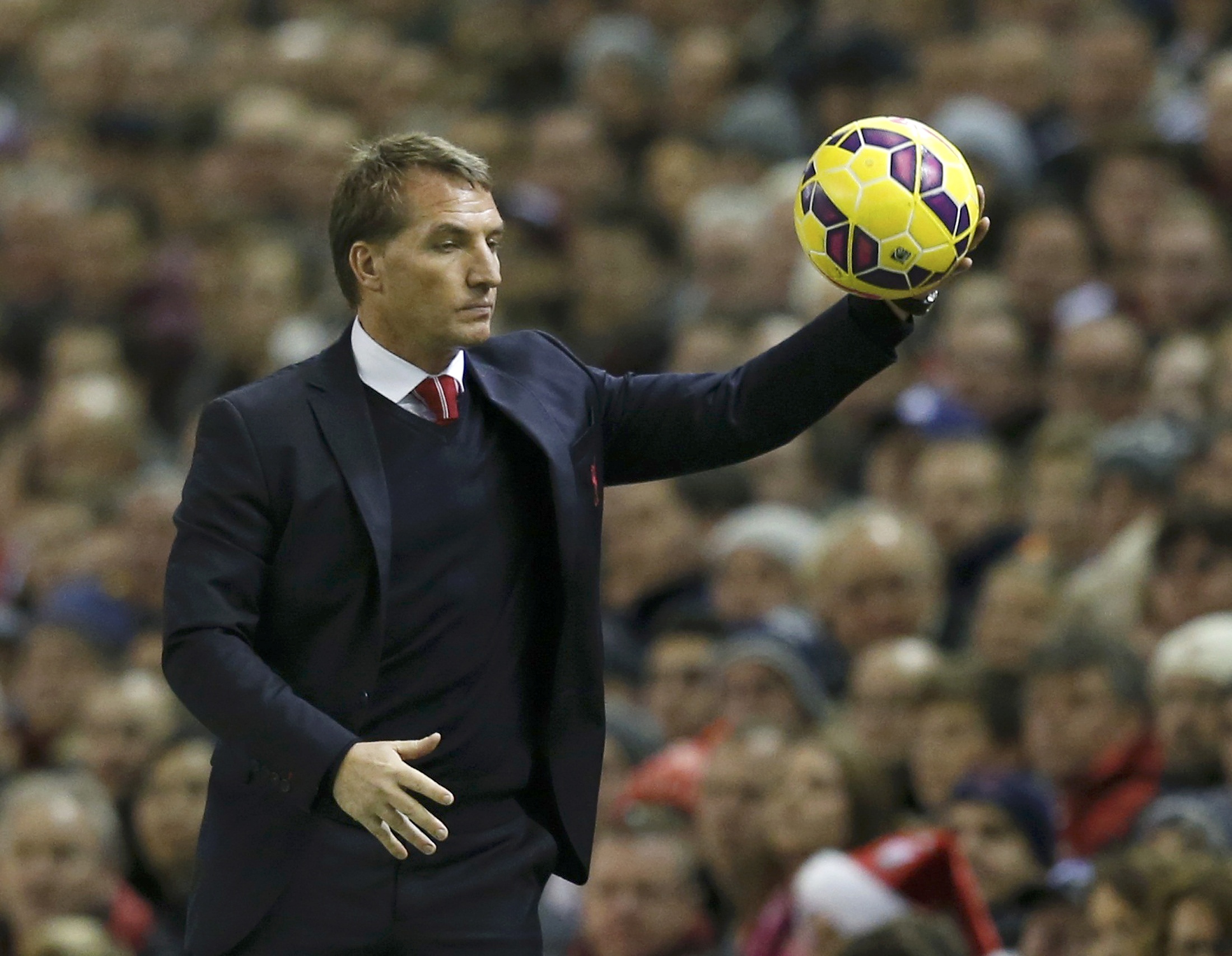 Liverpool manager Brendan Rodgers catches the ball during their English Premier League soccer match against Arsenal at Anfield in Liverpool